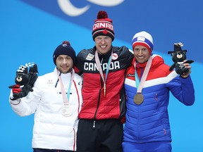 Canada’s Mark Arendz of Canada (centre) celebrates his gold medal for the men’s biathlon 12.5km standing on March 16, 2018, at the Paralympic Winter Games in Pyeongchang, South Korea. At left is silver medallist Benjamin Daviet of France and (right) bronze medallist Nils-Erik Ulset of Norway.