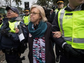 Federal Green Party Leader Elizabeth May, centre, is arrested by RCMP officers after joining protesters outside Kinder Morgan's facility in Burnaby, B.C., on March 23, 2018.