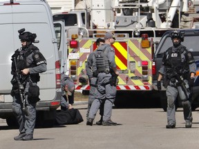 Calgary police tactical team members at the shooting scene of a police officer in Calgary, Alta. on Tuesday, March 27, 2018.