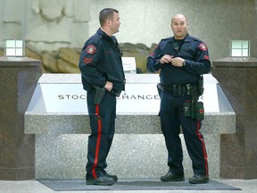 Calgary police officers attend the main lobby of the Stock Exchange Building in downtown Calgary on Friday, March 23, 2018. A handful of protesters staged a sit-in outside the Kinder Morgan office on the 27th floor.