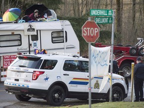 A protester sits on top of a trailer outside the main gates of Kinder Morgan in Burnaby, B.C., Wednesday, Jan. 10, 2018. Trans Mountain is seeking an injunction against a group of anti-pipeline activists protesting construction at two terminals in Burnaby, B.C.