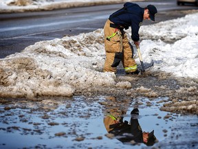 Firefighter Danny Moir helps his co-workers drain the water from the entry to Fire Station 21 in Calgary on Friday March 16, 2018. Leah Hennel/Postmedia