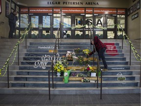 A man drops of flowers at a memorial located inside the Elgar Petersen Arena in Humboldt, SK on Saturday, April 7, 2018.