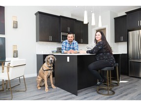 Andres and Carolina Zuleta with their dog Bruno in the GeorgeTown at Reunion by Slokker Homes show home in Airdrie.