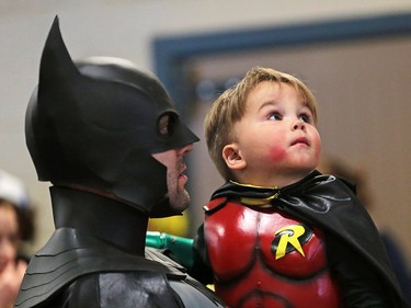 Hutton Staat is a little Robin in the hands of dad Lee as Batman as they wait for the costume contest to start at the Calgary Expo on Saturday April 28, 2018.