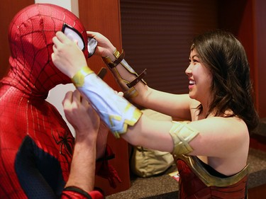 Superhero Help Ñ Donna Tran as Wonder Woman helps Spiderman aka Colin Crawe with his costume as they enter the Calgary Expo at Stampede Park on Sunday, April 29, 2018.