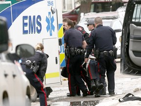 Calgary Police tend to one of their own who was shot at scene in Abbeydale on Tuesday March 27, 2018. Darren Makowichuk/Postmedia