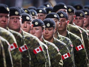 Members of the Canadian Armed Forces march during the Calgary Stampede parade in Calgary, Friday, July 8, 2016.The federal government has agreed to expand the scope of a landmark deal to financially compensate members of the military and other agencies who were investigated and sometimes fired because of their sexual orientation.