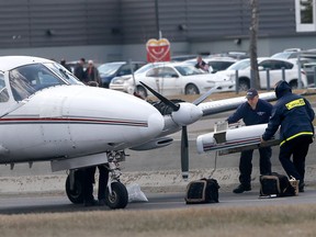 Investigators look over a small plane that crash landed on 36 St. just before 16 Ave. N.E. in Calgary on Wednesday, April 25, 2018.