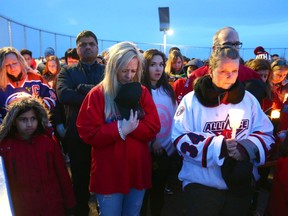 Supporters bow their heads during a moment of prayer during the StrazStrong Vigil in Airdrie on Friday, April 13, 2018. The vigil was held for local hockey player Ryan Straschnitzki who was paralyzed in the Humboldt bus crash a week ago.