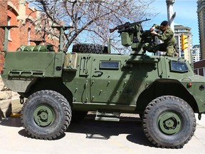 Sgt Jesse Anderson, from the King's Own Calgary Regiment works on a newly delivered Tactical Armoured Patrol Vehicle which was on display in front of Mewata Armoury in downtown Calgary on Sunday, April 22, 2018. The Regiment was celebrating the Saint George's Day Parade in the Armoury.