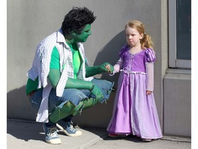 Shawn Throp, dressed as the Incredible Hulk, encourages his daughter Jovie, 3, dressed as Rapunzel, during the Parade of Wonders to kick off the Calgary Comic & Entertainment Expo.