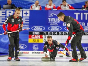 Team Canada's Brad Gushue lets go with a shot while sweepers Geoff Walker, left, and Brett Gallant prepare to work the rock during action at the World Curling Championships in Las Vegas, Nev. The Gushue rink defeated Team Italy 8-7 on Monday to improve to 3-1 in round-robin play.