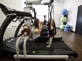 Neuro Exercise Specialist and Co-founder of ReYu, Nancy Morrow works with Evelyn Moore on the treadmill at the ReYu Paralysis Recovery Centre in Edmonton Alta, on Wednesday April 4, 2018.