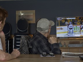 Eva Mansell, left and Ed Wagner watch an NHL playoff game on their new TV at the Friendship Manor senior living facility on April 14, 2018.