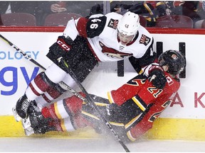Arizona Coyotes' Trevor Murphy (left) runs into Calgary Flames' Garnet Hathaway during first period NHL action in Calgary, Alta., Tuesday, April 3, 2018.