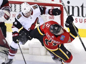 Calgary Flames' Garnet Hathaway (right) is knocked down by Arizona Coyotes' Trevor Murphy in front of the Arizona net during second period NHL action in Calgary, Alta., Tuesday, April 3, 2018