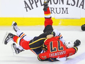 Mark Jankowski fights Drake Caggiula of the Edmonton Oilers at the Saddledome on March 31, 2018.