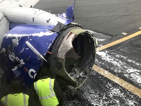 The engine on a Southwest Airlines plane is inspected as it sits on the runway at the Philadelphia International Airport after it made an emergency landing in Philadelphia, Tuesday, April 17, 2018.