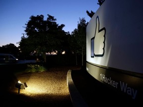 FILE - In this Jun 7, 2013, file photo, the Facebook "like" symbol is illuminated on a sign outside the company's headquarters in Menlo Park, Calif. Australian authorities say they are investigating whether Facebook breached the country's privacy law when personal information of more than 300,000 Australian users was obtained by Cambridge Analytica, a Trump-linked political consulting firm, without their authorization.
