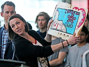 Former Olympic bobsledder Helen Upperton shows a poster that she made as a child for the 1988 Calgary Winter Games as athletes hold a press conference and panel discussion to encourage the city of Calgary to continue exploring a bid for the 2026 Olympics.