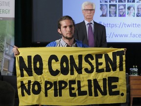 Trans Mountain Pipeline protester Gabriel D'astous interrupts a speech by Natural Resources Minister Jim Carr at the "Positive Energy" conference at the University of Ottawa on April 23, 2018.