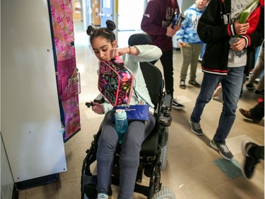 Hana Hassan, 12, goes to her locker between classes at A.E. Cross in Calgary. Leah Hennel/Postmedia