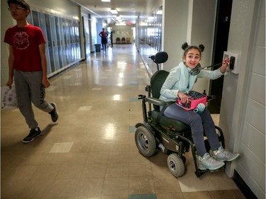 Hana Hassan, 12, takes the elevator to the first floor for another class at A.E. Cross school in Calgary. Leah Hennel/Postmedia