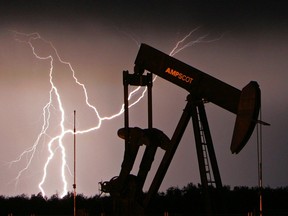 Lightning strikes in the distance as an oil pump-jack sits idle west of Edmonton.