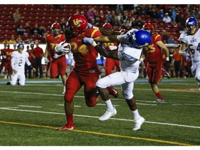 CALGARY, AB -- The U of C Dino's Boston Rowe pushes off a tackle during game action against UBC at McMahon Stadium in Calgary, on September 9, 2016. --  (Crystal Schick/Postmedia)