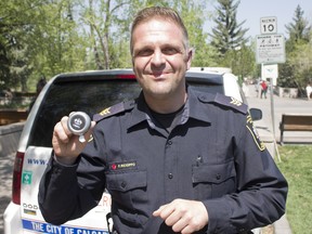 Fausto Ricioppo, community standards sergeant with the city of Calgary, shows off a bike bell that the city will be handing out as part of their pathway safety blitz on Wednesday, May 16, 2018. (Zach Laing / Postmedia Network)