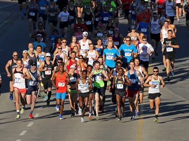 Elite racers lead out the pack at the start of the Scotiabank Calgary Marathon and Half Marathon at Stampede Park on Sunday May 27, 2018.