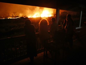 Residents view lava erupting from a Kilauea volcano fissure at a small viewing party on a neighbor's porch, on Hawaii's Big Island on May 19, 2018.