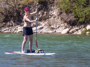 A paddle boarder enjoys the cooling waters of the Bow River near Bowness Park on a hot Tuesday, May 15, 2018. Gavin Young/Postmedia