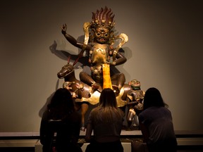 Visitors sit and take in a statue of the goddess Palden Lhamo in the Glenbow Museum's Art of Asia exhibit on Wednesday, May 24, 2018. After about 30 years the long running exhibit will soon end.