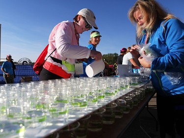 Volunteers prepare water for runners at the finish line of the Scotiabank Calgary Marathon and Half Marathon at Stampede Park on Sunday May 27, 2018.