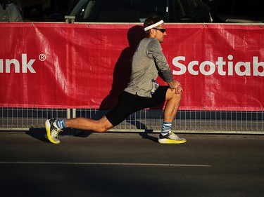 Igor Lysov stretches before running at the Scotiabank Calgary Marathon and Half Marathon at Stampede Park on Sunday May 27, 2018.