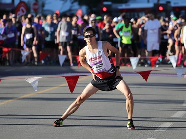 Michael Nishiyama stretches before the start of the Jugo Juice 10 KM event during the Scotiabank Calgary Marathon Stampede Park on Sunday May 27, 2018.