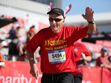 Calgary runner Gerry Miller waves as he crosses the finish line as a pace bunny during the Centaur Subaru Half Marathon event at Stampede Park on Sunday May 27, 2018.