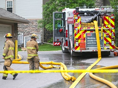 Firefighters clean up after an early morning four alarm fire caused extensive damage to a condo complex in Inglewood on Wednesday May 30, 2018.