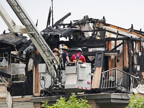 Fire investigators examine an early morning four alarm fire which caused extensive damage to a condo complex in Inglewood on Wednesday May 30, 2018.