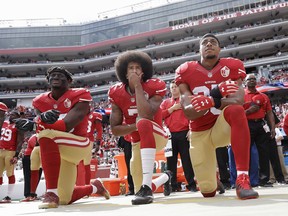 In this Oct. 2, 2016 file photo, from left, San Francisco 49ers outside linebacker Eli Harold, quarterback Colin Kaepernick and safety Eric Reid kneel during the national anthem before a game against the Dallas Cowboys.