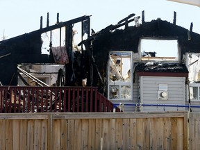 View from the back lane shows scorched homes on Coventry Hills Way N.E. on Monday May 28, 2018.