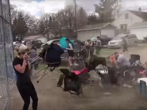 This screen shot from Kendall Hardy's video on YouTube shows a dust devil sending lawn chairs flying during a softball game in Vulcan, Alberta