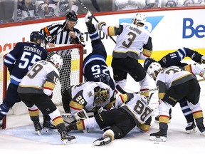 Players crash the net as Marc-Andre Fleury of the Vegas Golden Knights holds onto the puck against the Winnipeg Jets during the third period at Bell MTS Place on May 14, 2018 in Winnipeg.
