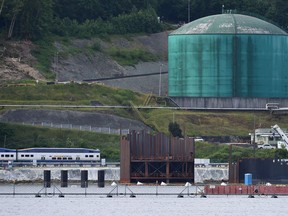 The West Coast Express passenger train passes in front of Kinder Morgan's Trans-Mountain marine terminal, in Burnaby, B.C., on Tuesday, May 29, 2018.