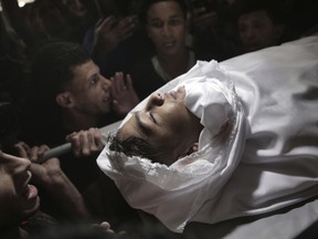 Mourners chant angry slogans as they carry the body of 15 year-old Palestinian Jamal Afaneh during his funeral in Rafah refugee camp, southern Gaza Strip, Sunday, May 13, 2018. Afaneh died from his injuries after being shot on Friday by Israeli troops during the ongoing protest along the Gaza Strip border with Israel.