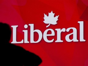 A Liberal Party of Canada logo is shown on a giant screen as a technician looks on during day one of the party's biennial convention in Montreal, Thusday, February 20, 2014. THE CANADIAN PRESS/Graham Hughes ORG XMIT: CPT105