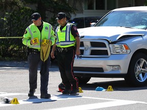 Traffic investigators near the intersection of 97th Ave S.W. and Acadia Dr. where two people were struck by a car on May 22, 2018.