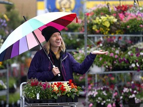 Breanne Schweitzer hopes it dosen't continue to rain on her long weekend as she leaves the Plantation Garden Centre in Calgary on Thursday May 17, 2018. Darren Makowichuk/Postmedia